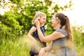 Young mother in nature holding little daughter in the arms. Royalty Free Stock Photo