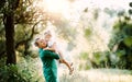 Young mother in nature holding small daughter in the arms in summer. Copy space. Royalty Free Stock Photo