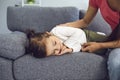 Young mother near her cute sleeping daughter on sofa at home. Parent watching lovely child taking daytime nap Royalty Free Stock Photo