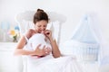 Young mother and newborn baby in white bedroom Royalty Free Stock Photo