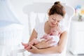 Young mother and newborn baby in white bedroom Royalty Free Stock Photo