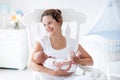 Young mother and newborn baby in white bedroom Royalty Free Stock Photo