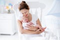 Young mother and newborn baby in white bedroom Royalty Free Stock Photo