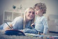 Young mother painting color book with her son . Royalty Free Stock Photo