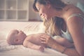 Young mother playing with her baby boy in bed. Mother enjoying i Royalty Free Stock Photo