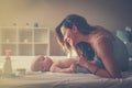 Young mother playing with her baby boy in bed. Mother enjoying i Royalty Free Stock Photo