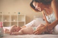 Young mother playing with her baby girl in bed. Mother enjoying Royalty Free Stock Photo