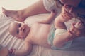 Young mother playing with her baby girl in bed. Royalty Free Stock Photo