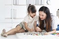 Young mother playing with her daughter in morning in bedroom. Mother and her child girl playing and hugging. Royalty Free Stock Photo