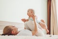 Young mother playing with her newborn baby son at home. Family having fun lying on bed in bedroom Royalty Free Stock Photo