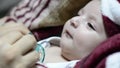 Young mother playing with a pacifier with two months baby