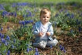 Young mother playing and talking with a baby boy son on a muscari field in Spring - Sunny day - Grape hyacinth - Riga