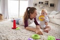 Young mother playing with toddler son on the floor at home Royalty Free Stock Photo