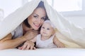 Young mother plays with her baby under a blanket Royalty Free Stock Photo