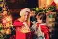 Young mother plays with her son near Christmas decorated tree and fire place. Bright New Year`s interior. Happy new year Royalty Free Stock Photo