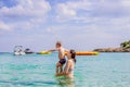 Young mother plays with her young son in the sea