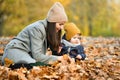 Young mother plays with a small child in an autumn park Royalty Free Stock Photo