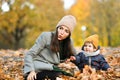 Young mother plays with a small child in an autumn park Royalty Free Stock Photo