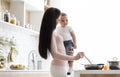 Young mother preparing dinner with little son, kitchen interior Royalty Free Stock Photo