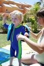 Young mother preparing her child for swimming lesson