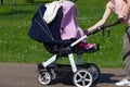 young mother pushing buggy Royalty Free Stock Photo