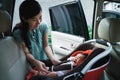 Young mother putting her daughter in car seat Royalty Free Stock Photo