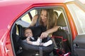 Mother fasten her son in the car seat and putting on his seat belt Royalty Free Stock Photo