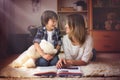 Young mother, read a book to her child, boy in the living room o Royalty Free Stock Photo