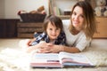 Young mother, read a book to her child, boy in the living room o Royalty Free Stock Photo