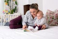 Young mother, reading a book to her baby boy, showing him pictur Royalty Free Stock Photo