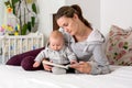 Young mother, reading a book to her baby boy, showing him pictures Royalty Free Stock Photo