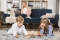Young mother relax on sofa with laptop, two kids children playing with wooden blocks Royalty Free Stock Photo