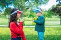 Young mother relaxing together with her little child, adorable toddler boy in summer outdoors drinking from a canteen and wearing