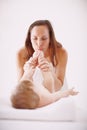 Let me kiss those cute clean toes. A young mother showing her baby daughter affection by kissing her toes. Royalty Free Stock Photo