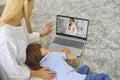 Young mother and sick little boy using online medical service at home, consulting pediatrician through video chat Royalty Free Stock Photo