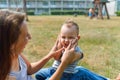 Young mother sitting face to her cute toddler son playing clapping hands in park, lifestyle fun concept Royalty Free Stock Photo