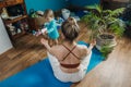 Young mother sitting on the floor, enjoy meditation do yoga exercise at home with his little daughter baby girl. Mental