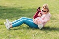 A young mother is sitting on the grass, playing with her baby. Recreation in the park with a child. Top view. Children`s day Royalty Free Stock Photo