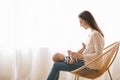 Young mother sitting in wicker chair with baby on lap Royalty Free Stock Photo