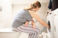 Performing everyday chores holding child in your arms Royalty Free Stock Photo