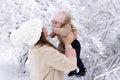 A young mother with a small child plays in the snow Royalty Free Stock Photo