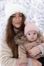 A young mother with a small child plays in the snow Royalty Free Stock Photo