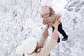 A young mother with a small child plays in the snow Royalty Free Stock Photo