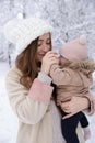 A young mother with a small child plays in the snow Royalty Free Stock Photo