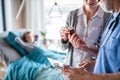 Mother of small hospitalized girl talking to doctor in hospital. Royalty Free Stock Photo