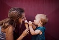 Young mother with small toddler girl outdoors in summer, eating ice cream.