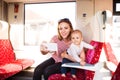 Young mother with smartphone travelling with baby by train. Royalty Free Stock Photo