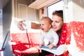 Young mother with smartphone travelling with baby by train. Royalty Free Stock Photo