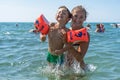 Young mother and smiling baby boy son in green baseball cap playing in the sea in the day time. Positive human emotions, feelings, Royalty Free Stock Photo