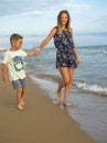 Young mother and smiling baby boy son playing on the beach on the Sunset. Positive human emotions, feelings, joy. Funny cute child Royalty Free Stock Photo